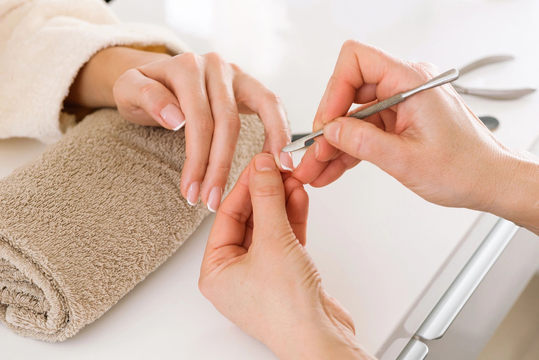 Nail technician cutting cuticle